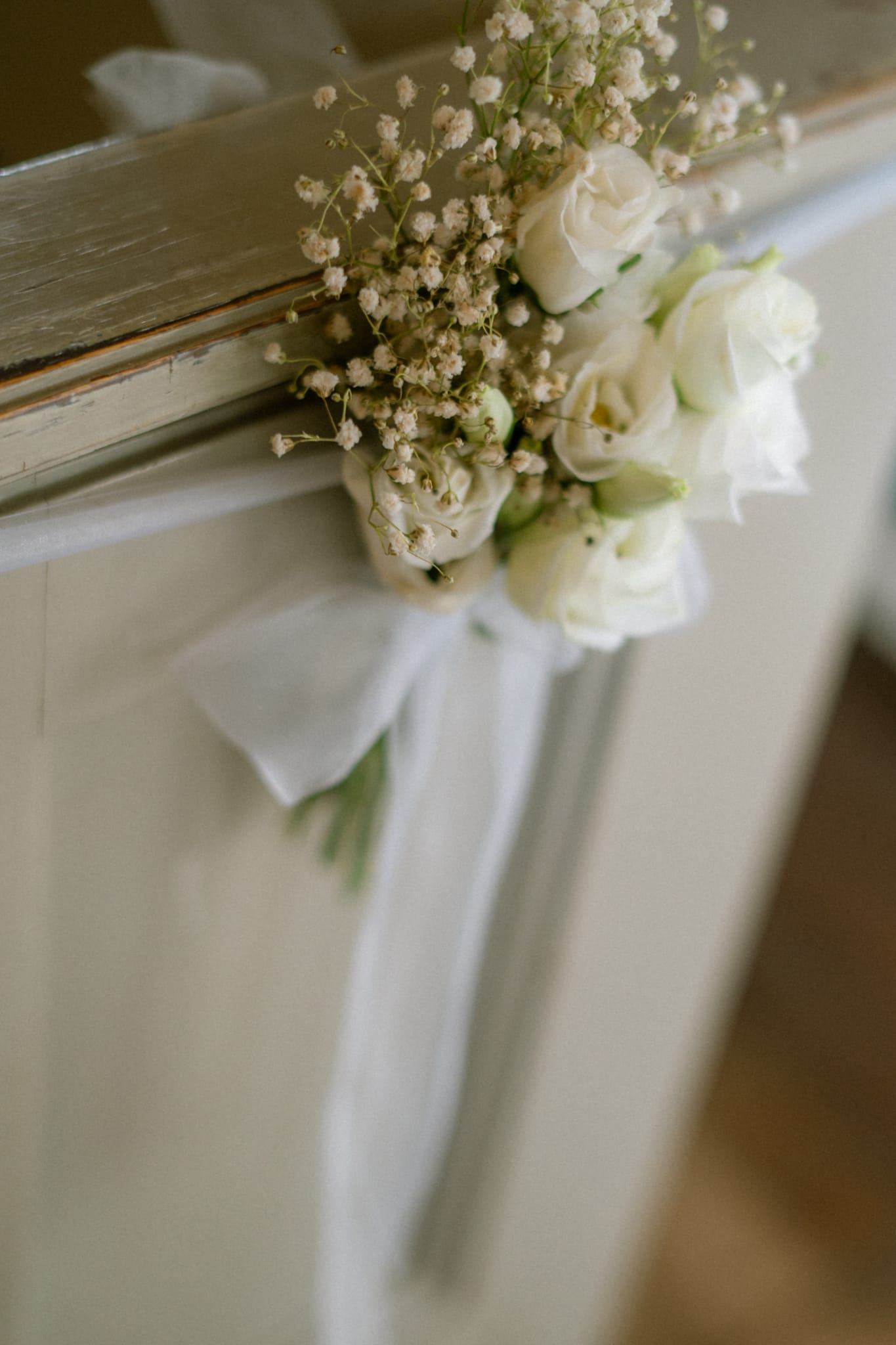 Blumenschmuck mit Schleifenband am Türrahmen