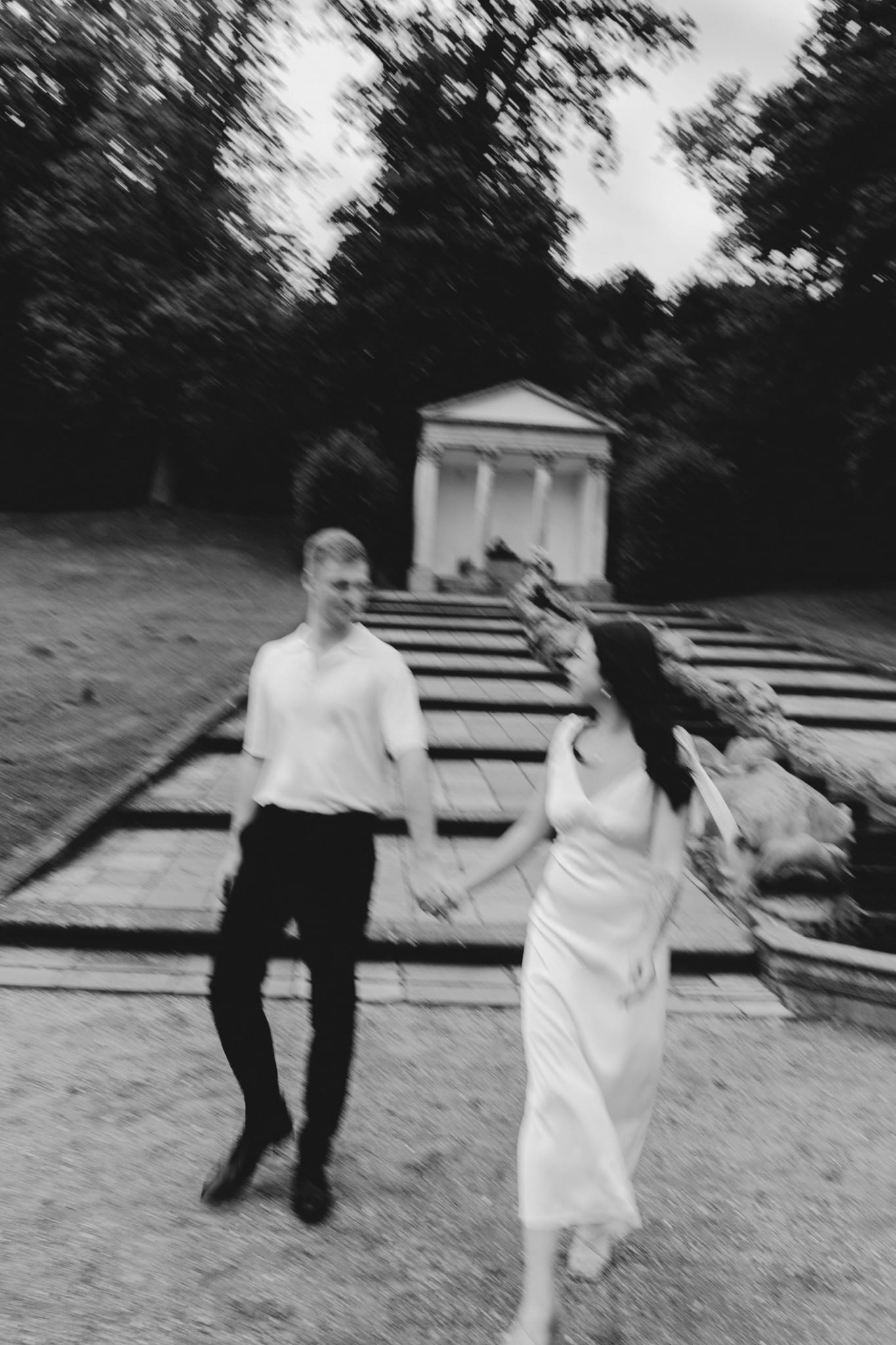 Paar spaziert Hand in Hand vor einem Gartentempel